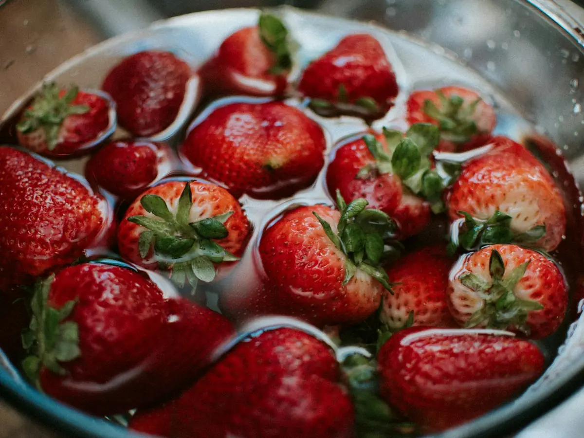 Strawberry segar direndam dalam wadah berisi cairan fermentasi